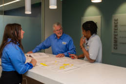 Three people discussing blueprint