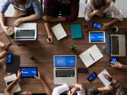 Team on laptops around table